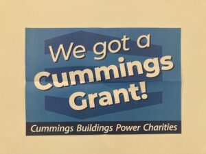 Poster that reads: "We got a Cummings Grant! Cummings Buildings Power Charities"