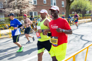 A visually impaired athlete runs the 2024 Boston Marathon with his guide by his side.